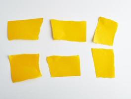 pedazos vacíos de papel amarillo sobre un fondo blanco foto
