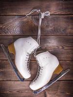 white leather skates hanging on a nail photo