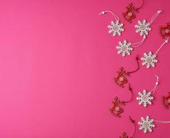 wooden carved Christmas decorations for the holiday tree on a pink background photo