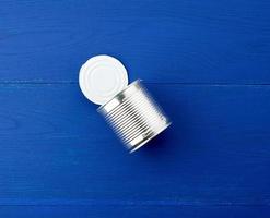 open large metal tin can on a blue wooden background from parallel boards photo