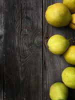 Ripe pear on a gray wooden surface, empty space photo
