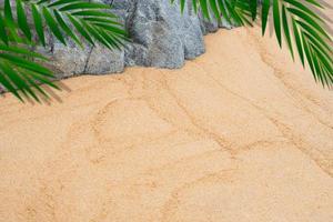 fondo de textura de arena, piedra de roca y marco de hojas de palma borrosas, playa tropical de vista superior con hoja de coco borrosa en arena marrón, fondo de fondo duna de arena del desierto para la presentación de productos de verano foto