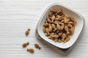 A bowl of dog food on a wooden floor. photo