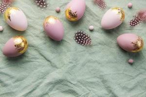 Easter eggs are painted with violet and green paint on a gray linen background. photo