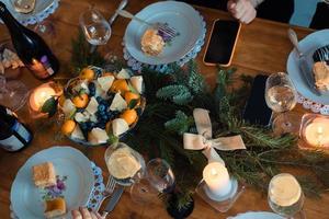 Christmas dinner with tangerines, candles and spruce branches for decoration photo