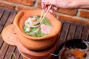 Hot pot thai style. Hot pot with clear soup in the clay cooking pot. photo