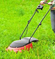 Mowing lawns, lawn mower on green grass photo