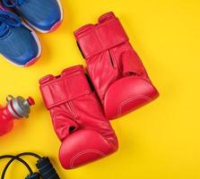 pair of red boxing gloves and blue sneakers, top view photo