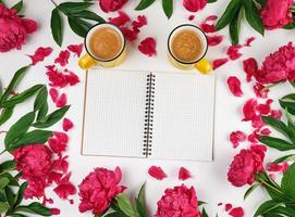 empty open notebook in a cage and a two yellow cups  of coffee photo