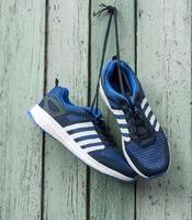 pair of male blue textile sneakers suspended on laces photo