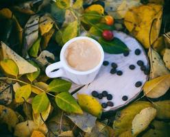taza blanca con café espresso en un tocón de madera foto