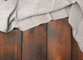 gray linen towel on wooden background, top view photo