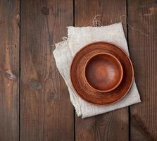 empty brown ceramic plates on a wooden table photo