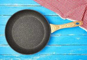 empty black round frying pan with wooden handle photo