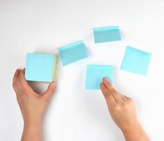 lot of blue stickers on a white background and two female hands photo