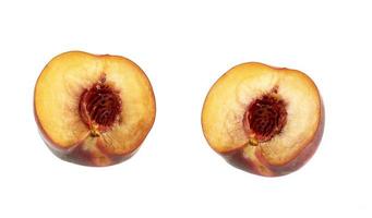 two halves of a ripe peach with a pit isolated on a white background photo