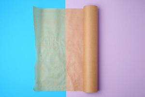 unwrapped a roll of brown parchment paper on a colored background photo