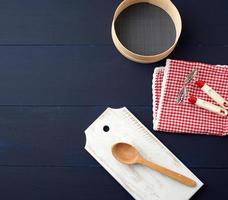 white cutting board, wooden spoon and round flour sieve photo