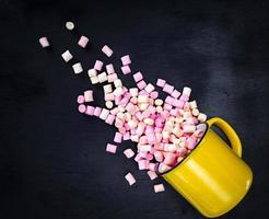 yellow mug with multicolored marshmallow photo