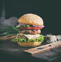 hamburguesa con queso en una tabla de madera marrón foto