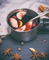 vino caliente en un cucharón de aluminio foto