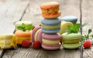 stack of baked multicolored macarons and different flavors on a gray wooden table, delicious dessert photo