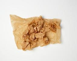 crumpled piece of brown paper sheet on white background photo