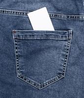 empty white paper card in the back pocket of blue jeans photo