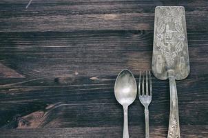 Vintage cutlery on rustic wooden background. photo