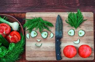 Fresh tomatoes and cucumber in a bowl and on a kitchen board photo