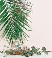 stage for displaying products, cosmetics with a round wooden podium and a glass vase with a bouquet of flowers. beige background photo