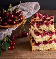 stack of square slices of a baked pie with cherry berries photo