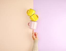 stack ceramic cups are supported by a female hand photo