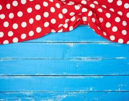 red textile towel with white circles on a blue wooden background photo