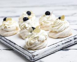 small baked round cake meringue with whipped cream photo