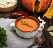 fresh pumpkin soup in a ceramic plate photo