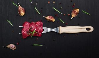 raw beef slices are strung on a kitchen fork photo