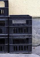 stack of empty black plastic crates photo