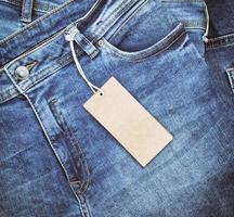 fragment of blue jeans with a brown paper tag photo