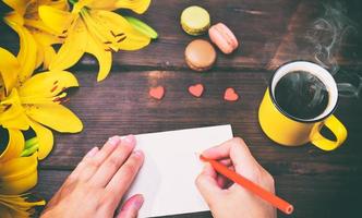 Cup of coffee and two female hands photo