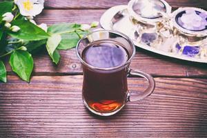 Black tea in a glass transparent glass with a handle photo