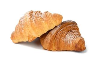 two baked croissants on a white isolated background, dessert for breakfast sprinkled with powdered sugar photo