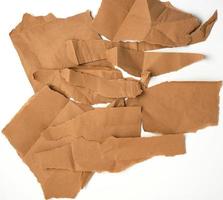 torn brown pieces of parchment paper on a white background photo