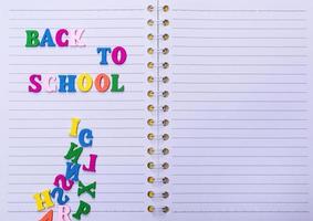 inscripción de regreso a la escuela en un cuaderno blanco foto