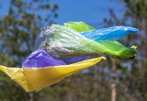 empty garbage plastic bags fly in the forest photo