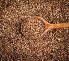 flax seeds in a wooden spoon on a pile photo