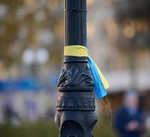 cinta de seda azul y amarilla atada a un tubo de metal. símbolo de la bandera ucraniana, lucha por la independencia foto