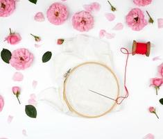 round wooden hoop and a red thread with a needle photo