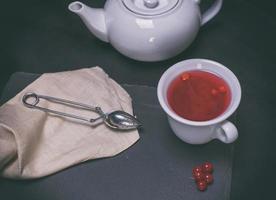 tea from berries of a viburnum in a white ceramic cup photo