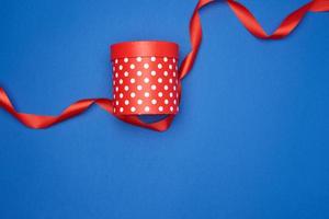 closed cardboard red box with white polka dots and red silk ribbon photo